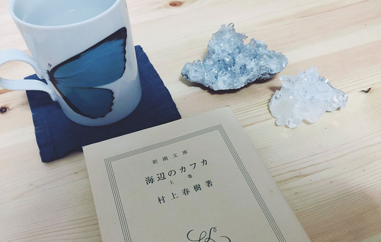 蝶が描かれたマグカップと裸の『海辺のカフカ』の文庫本